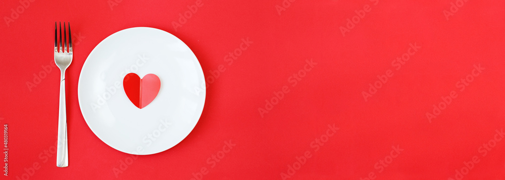 Heart on a white plate with fork on the red background Heart on a white plate with fork on the red background