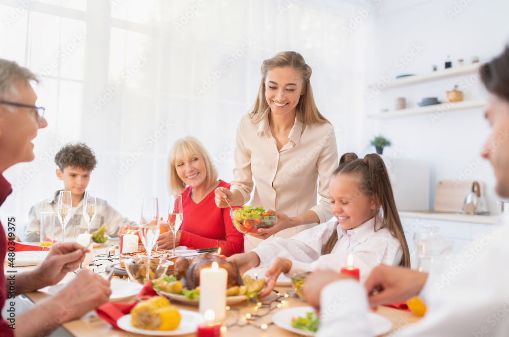 Happy extended multi generation family celebrating Thanksgiving or Christmas with festive turkey at home