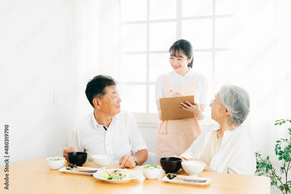 高齢者の食事をチェックする女性（栄養士）
