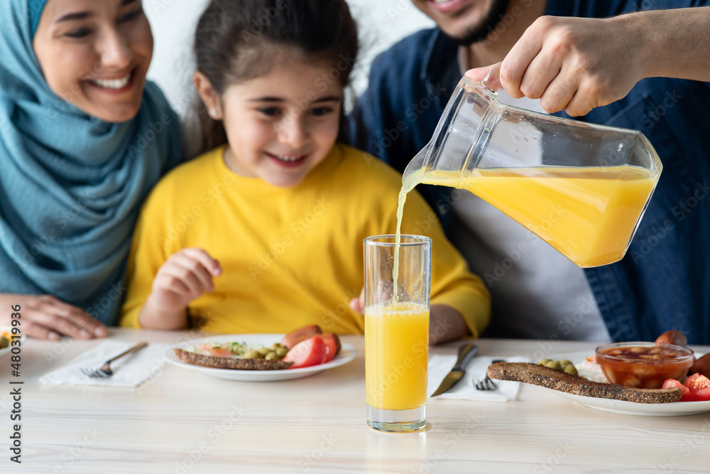 Orange Juice. Caring Man Pouring Healthy Vitamin Drink For Daughter And Wife Orange Juice. Caring Man Pouring Healthy Vitamin Drink For Daughter And Wife