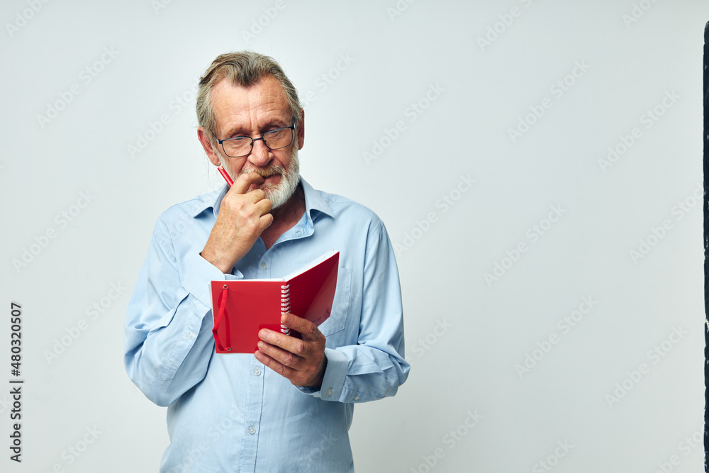 Photo of retired old man with red notebook and pen isolated background Photo of retired old man with red notebook and pen isolated background