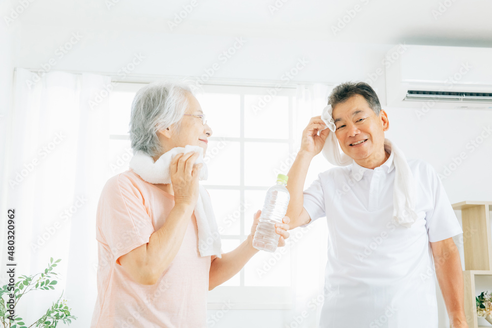 Obraz premium 家で運動する高齢者の男女（汗・笑顔） 