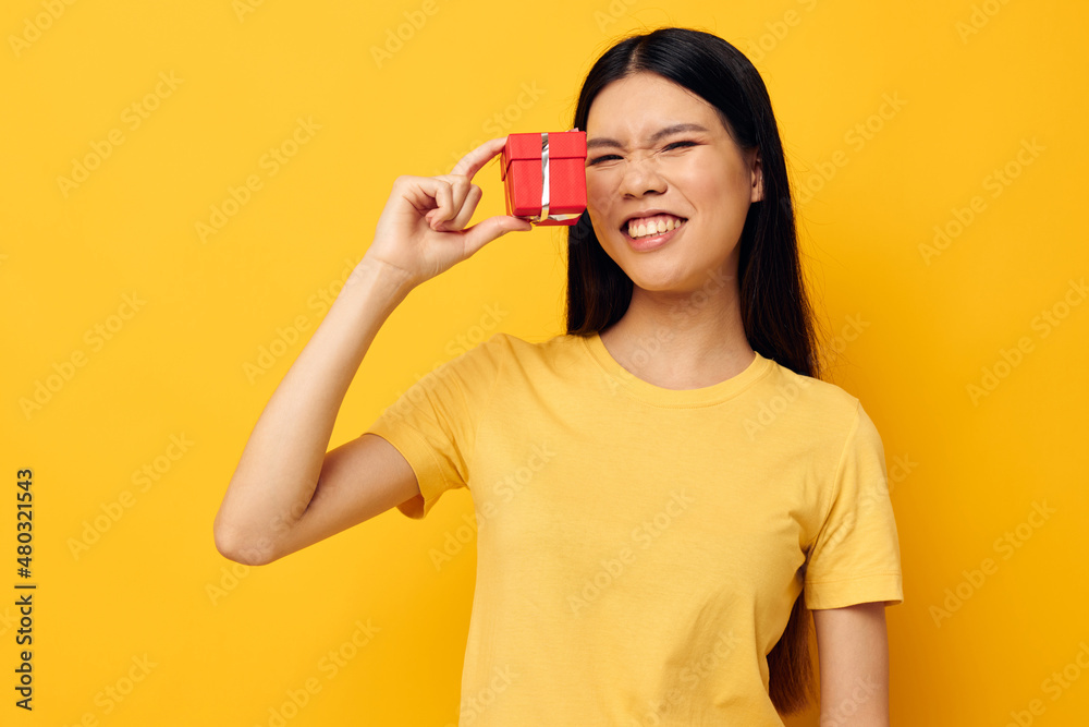 pretty brunette holding a gift box in his hands posing isolated background unaltered pretty brunette holding a gift box in his hands posing isolated background unaltered