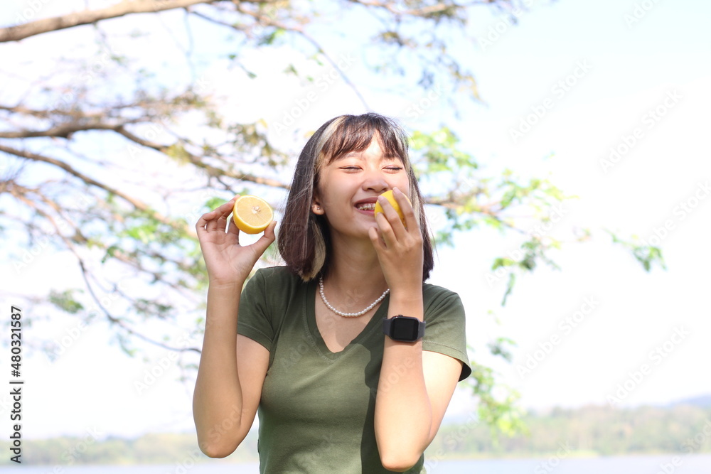 Beautiful asian woman showing fresh lemon