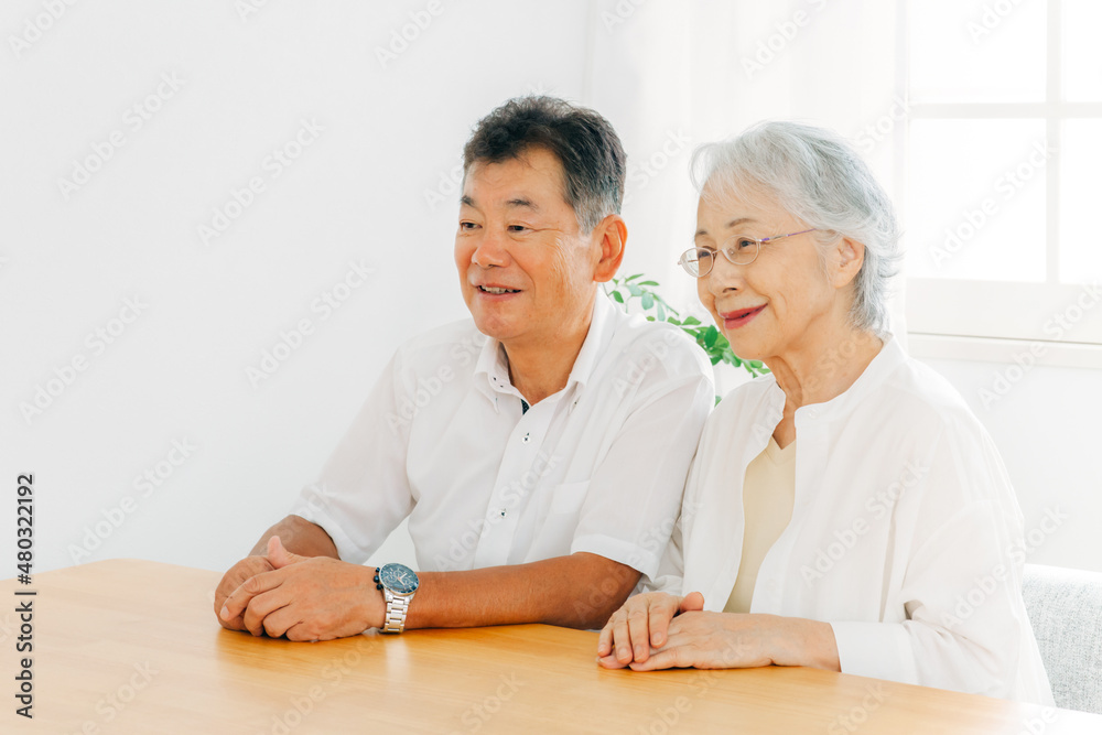 テーブルに座る高齢者夫婦（話す）
