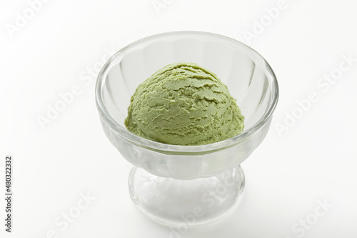 One scoop of green tea ice cream in glass cup on white background. photo
