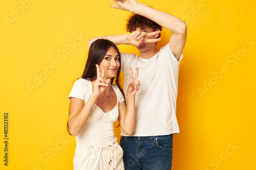 cute young couple standing side by side in white t-shirts posing Lifestyle unaltered