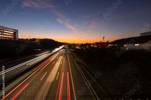 Autobahn mit Verkehr bei Nacht in der D  mmerung mit Lichterstreifen