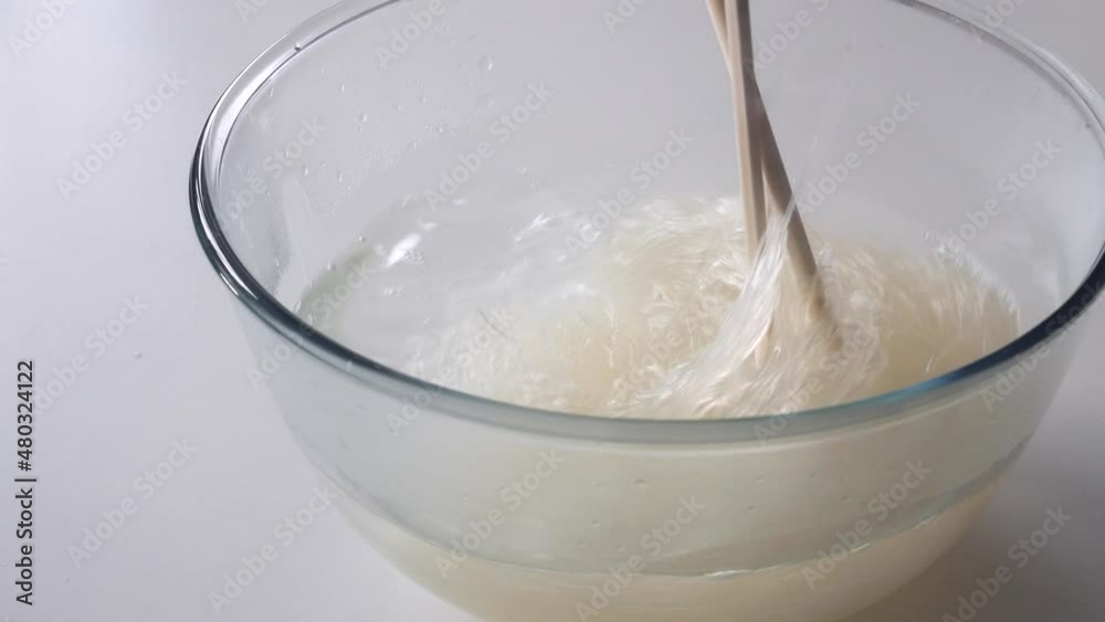 Stirring and rinsing cellophane noodles (funchose, fensi) in hot water with chopsticks. Cooking traditional Chinese food. Asian cuisine Stirring and rinsing cellophane noodles (funchose, fensi) in hot water with chopsticks. Cooking traditional Chinese food. Asian cuisine