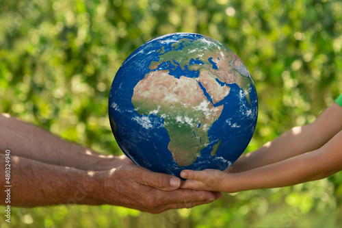Fototapeta Naklejka Na Ścianę i Meble -  Senior man and child holding Earth planet. Elements of this image furnished by NASA