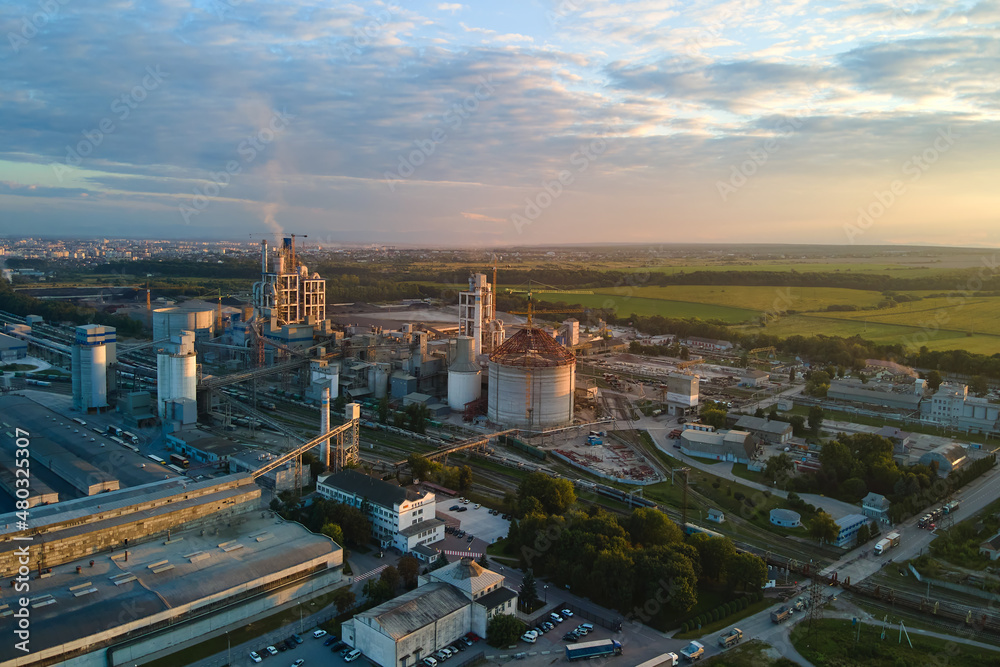 Aerial view of cement factory with high concrete plant structure and tower crane at industrial production area. Manufacture and global industry concept