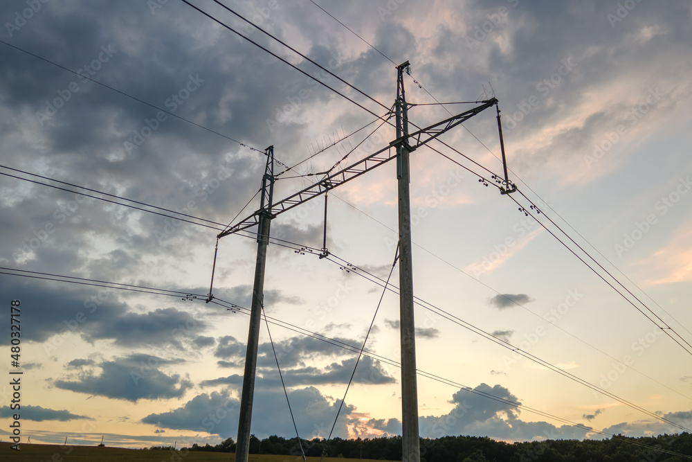 High voltage tower with electric power lines at sunset