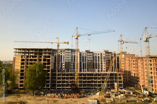 High multi storey residential apartment buildings under construction. Concrete and brick framing of high rise housing. Real estate development in urban area.