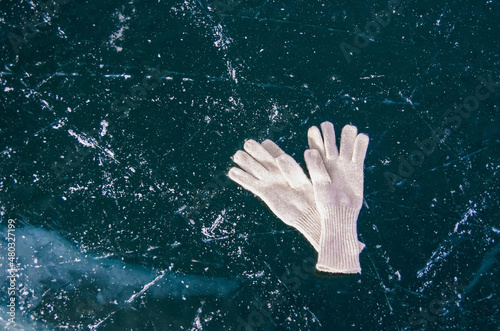 White gloves lie on the ice of frozen Lake Baikal. Winter vacation and travel concept