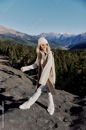 tourist in autumn clothes stands on a rock blue sky relaxation