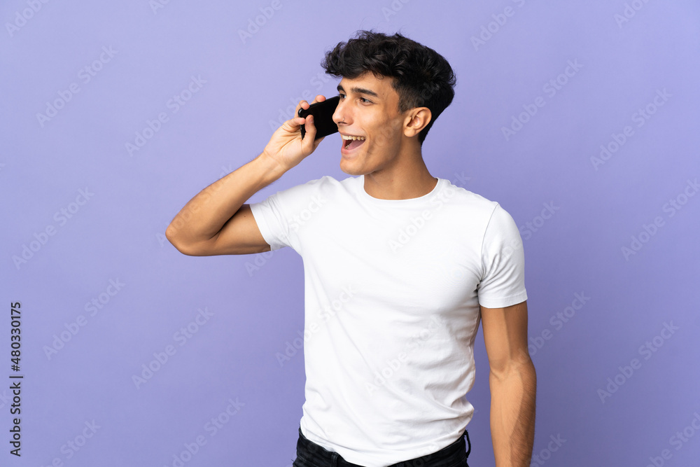 Young Argentinian man isolated on background keeping a conversation with the mobile phone Young Argentinian man isolated on background keeping a conversation with the mobile phone