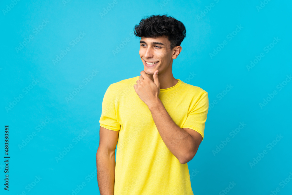 Young Argentinian man isolated on background looking to the side and smiling Young Argentinian man isolated on background looking to the side and smiling