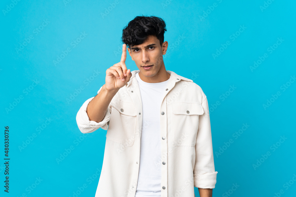Young Argentinian man isolated on background counting one with serious expression Young Argentinian man isolated on background counting one with serious expression