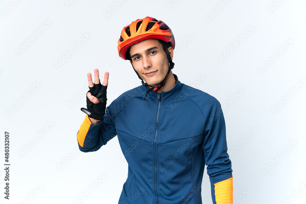 Young cyclist man isolated on background happy and counting three with fingers Young cyclist man isolated on background happy and counting three with fingers