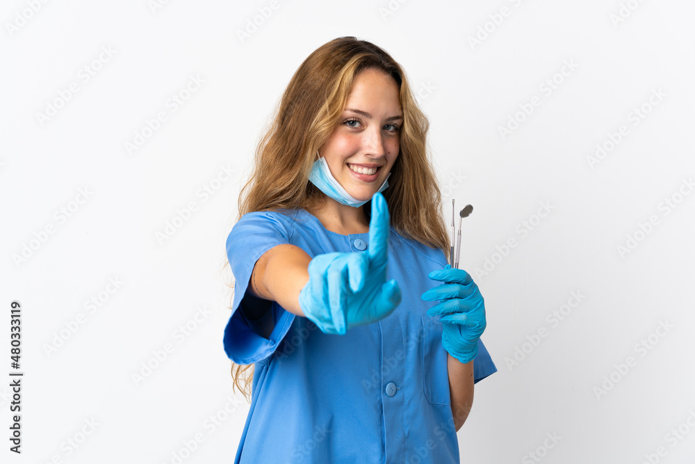 Woman dentist holding tools isolated on white background showing and lifting a finger Woman dentist holding tools isolated on white background showing and lifting a finger