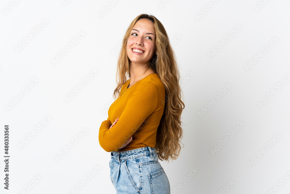 Young blonde woman isolated on blue background with arms crossed and happy Young blonde woman isolated on blue background with arms crossed and happy