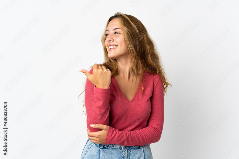 Young blonde woman isolated on blue background pointing to the side to present a product Young blonde woman isolated on blue background pointing to the side to present a product
