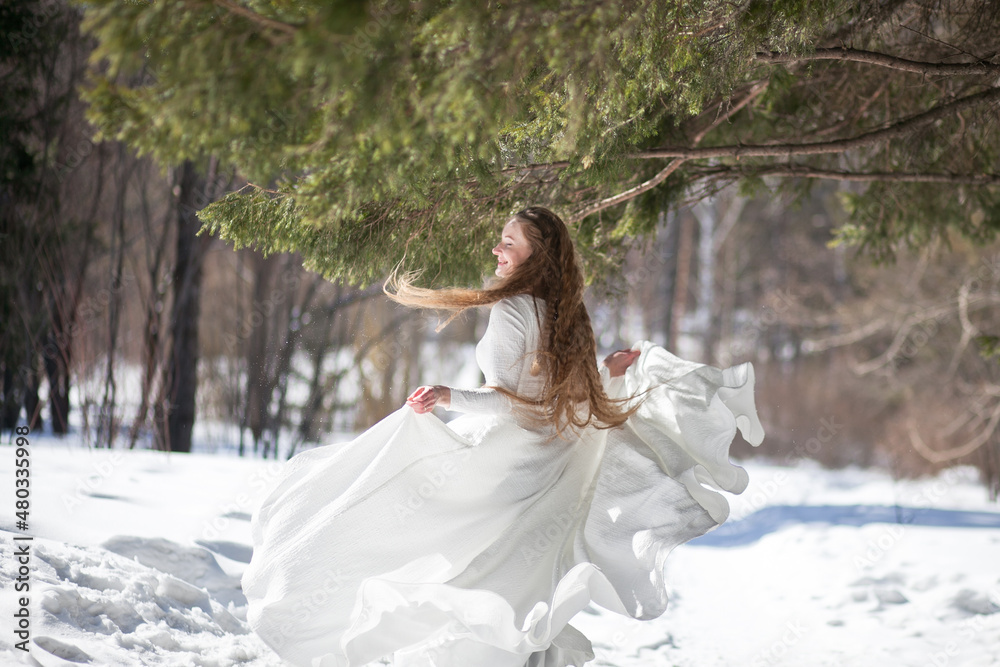 blonde with long hair, a girl in a long white dress walks in the winter forest, the snow queen, the bride with a bouquet of dianthus blonde with long hair, a girl in a long white dress walks in the winter forest, the snow queen, the bride with a bouquet of dianthus