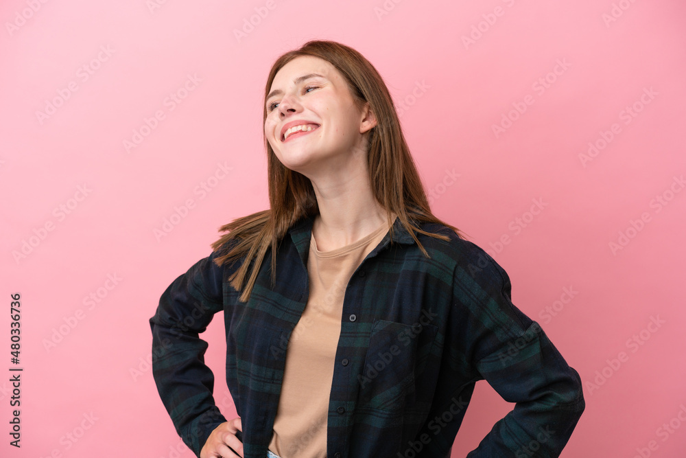 Young English woman isolated on pink background posing with arms at hip and smiling Young English woman isolated on pink background posing with arms at hip and smiling