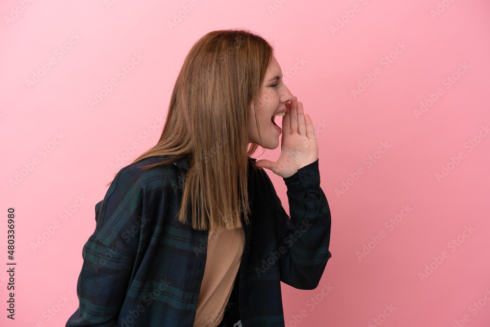 Young English woman isolated on pink background shouting with mouth wide open to the side Young English woman isolated on pink background shouting with mouth wide open to the side