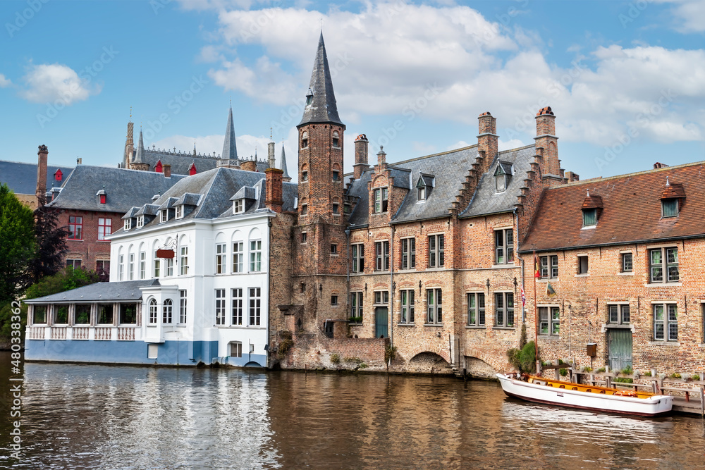 City view with historical houses, church, tower and famous canal in Bruges, Belgium.