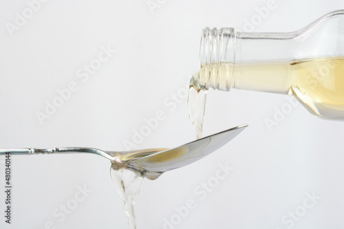 Pouring apple cider vinegar in a spoon photo