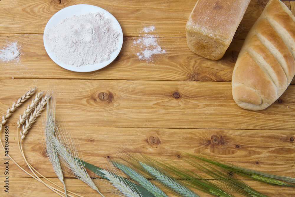 bread and flour on a wooden table bread and flour on a wooden table