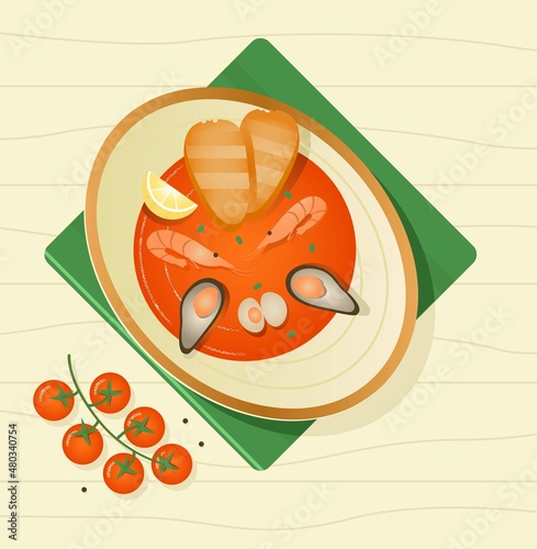 Red soup with seafood in a plate top view