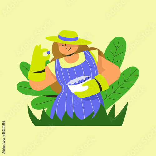 A woman in uniform and hat picks berries in the garden.