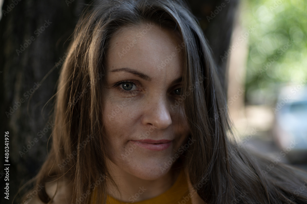 Portrait of a beautiful middle-aged brown-haired woman with long hair in the city Portrait of a beautiful middle-aged brown-haired woman with long hair in the city