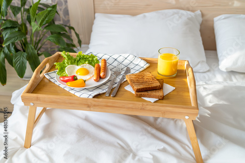 Breakfast on a tray in bed. Morning. Fried eggs in the shape of a heart with vegetables.