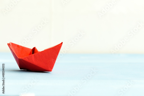The concept of leadership. The red flagship paper ship leads the others ahead on a blue background.