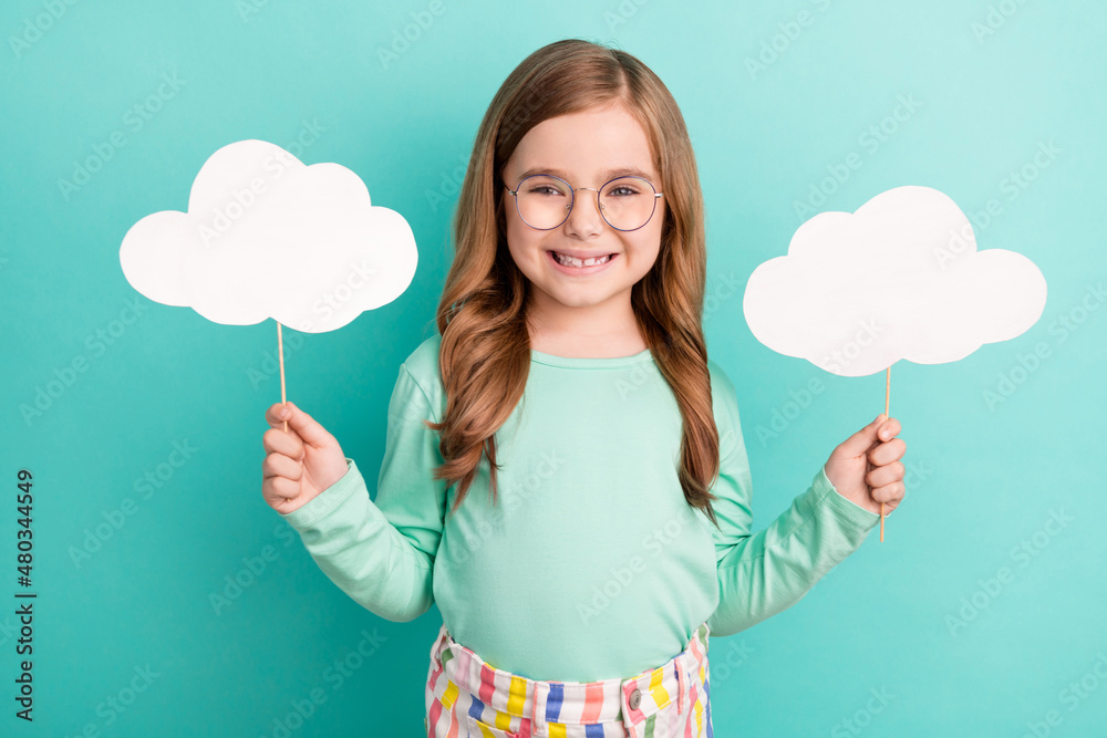 Photo of young girl happy positive smile hold paper cloud bubble poster isolated over teal color background Photo of young girl happy positive smile hold paper cloud bubble poster isolated over teal color background
