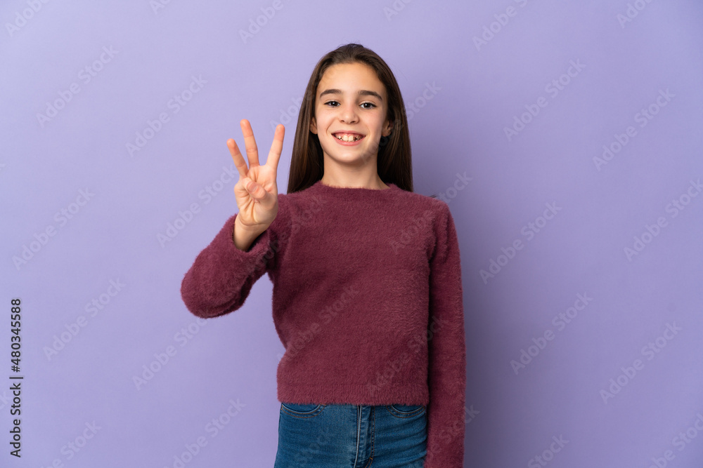 Little girl isolated on purple background happy and counting three with fingers Little girl isolated on purple background happy and counting three with fingers