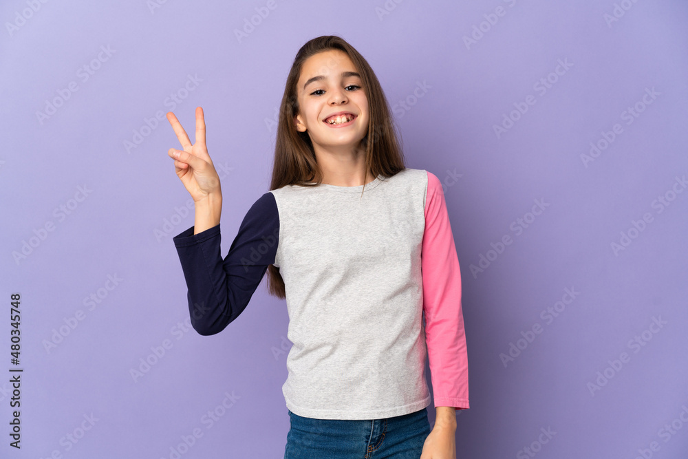 Little girl isolated on purple background smiling and showing victory sign Little girl isolated on purple background smiling and showing victory sign