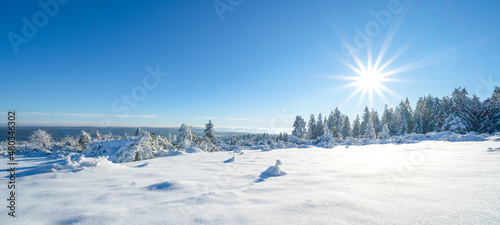 Stunning panorama of snowy landscape in winter in Black Forest - Snow view winter wonderland snowscape background banner with blue sky and sunshine