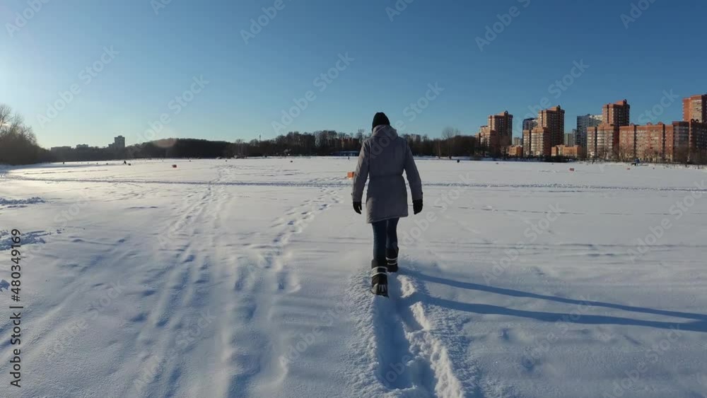 A girl warmly dressed walks in the snow A girl warmly dressed walks in the snow