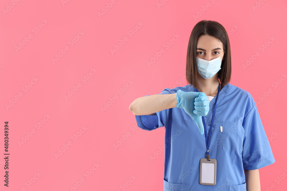 Female trainee nurse in gloves and mask on pink background Female trainee nurse in gloves and mask on pink background