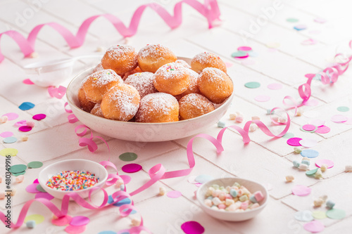 Krapfen, Berliner and donuts with streamers and confetti. Colorful carnival or birthday image