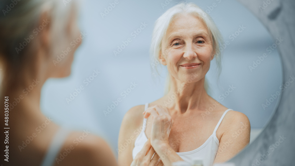 Portrait of Beautiful Senior Woman Morning Routine, Looking into Mirror Gently Applying Face Cream. Elderly Lady Makes Her Skin Soft, Smooth, Wrinkle Free with Natural anti-aging Cosmetics, Products Portrait of Beautiful Senior Woman Morning Routine, Looking into Mirror Gently Applying Face Cream. Elderly Lady Makes Her Skin Soft, Smooth, Wrinkle Free with Natural anti-aging Cosmetics, Products