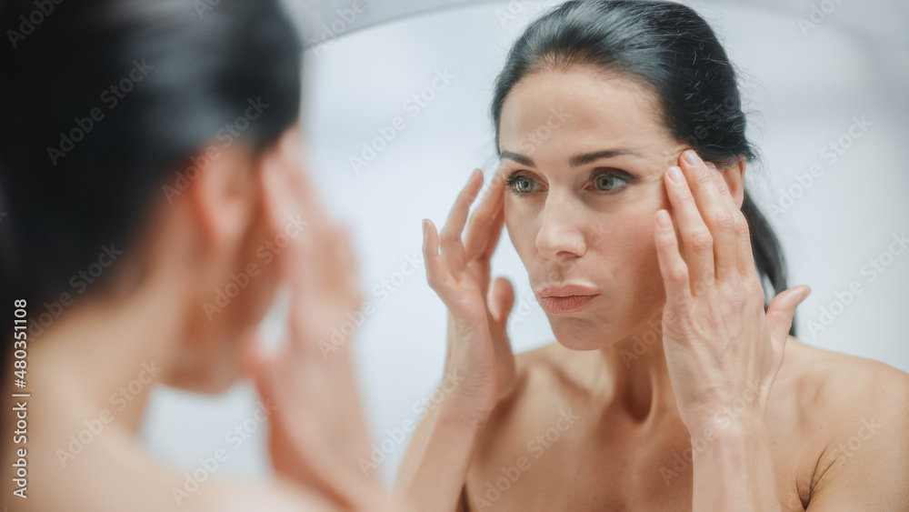 Caucasian Woman Looking in Mirror, Touching Beautiful Face, Soft Skin. Elderly Lady with Lush Black Hair. Female Beauty, Dignity, Grace. Sensual Wellness and Organic Skincare Products. Portrait Shot Caucasian Woman Looking in Mirror, Touching Beautiful Face, Soft Skin. Elderly Lady with Lush Black Hair. Female Beauty, Dignity, Grace. Sensual Wellness and Organic Skincare Products. Portrait Shot