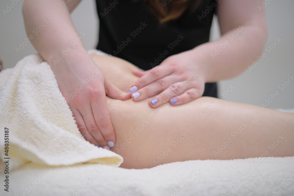 masseur makes anticellulite massage young woman in the spa salon. Special anticellulite treatment. massaging legs of young woman in spa salon. Body care in spa salon for young woman