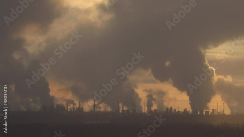 Factory chimneys pollute the air, environmental problems. It's snowing ash at sunset. Industrial pollution, exhaust fumes from the chimney. Industrial area, thick smoke. Climate change, ecology, atmos
