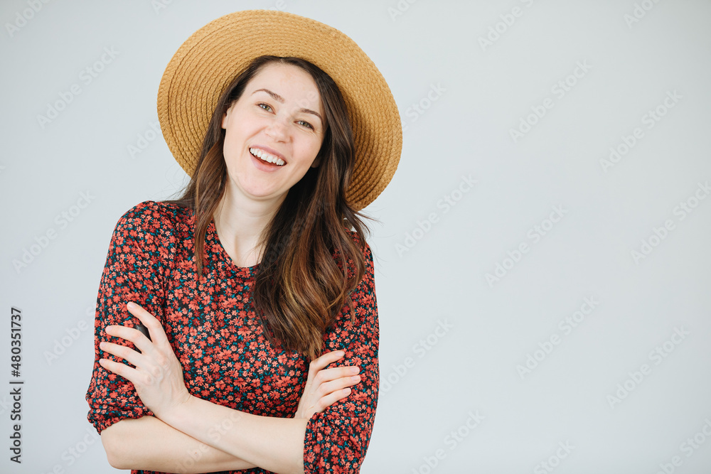 Beautiful gardener with straw hat on a white background. Have a nice holiday in the country. In quarantine in the country. Village girl smiles beautifully. Woman on vacation in the village 