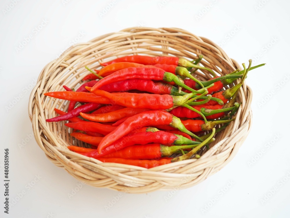 Chili pepper in wicker basket on  white background. closeup photo, blurred.